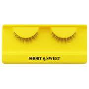 A pair of Boldface Lashes - Short and Sweet cruelty-free false eyelashes is showcased on a bright yellow tray with the words